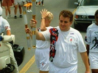 Professor Jam carrying the Olympic flame in the Centennial Olympic Games Torch Relay